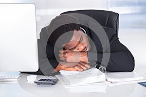 Stressed businessman sleeping in office