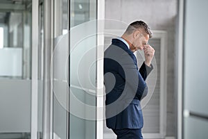 Stressed businessman suffering headache in office