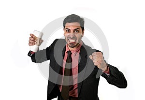 Stressed businessman in suit and tie crushing empty cup of take away coffee in caffeine addiction concept