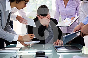 Stressed Businessman Surrounded By His Colleagues