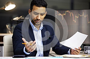 Stressed businessman trading on the stock market in a financial crisis. Trader in a bear market with paper, looking at