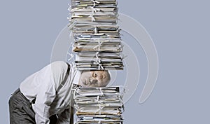 Stressed businessman under a pile of paperwork photo