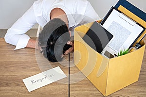 Stressed businessman will being resignation and packing belongings company and files into brown cardboard box, changing and