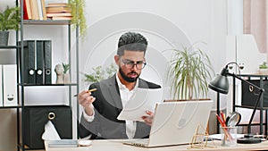 Stressed businessman work at unpaid bank debt, doing paperwork, planning budget, throws paper bills