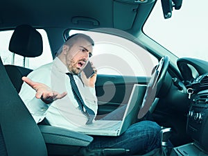 Stressed businessman working seated in car