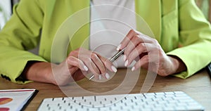 Stressed businesswoman is bored and holding pen nervously