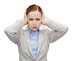 Stressed businesswoman with covered ears