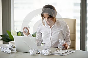 Stressed businesswoman holding crumpled paper trying to finish u