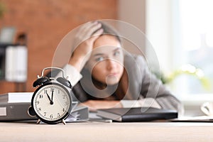 Stressed businesswoman missing deadlines in office