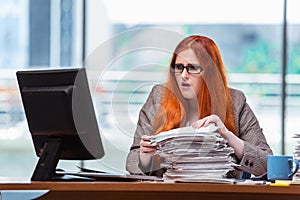 The stressed businesswoman with stack of papers
