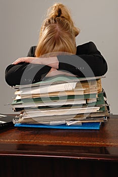 Stressed businesswoman - stack of paperwork