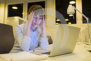 Stressed businesswoman working late in office