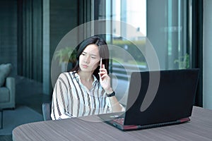 Stressed Casual Business Asian Woman phoning and thinking in fro
