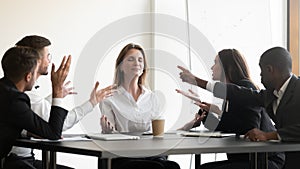 While stressed colleagues screaming to young businesswoman she meditating