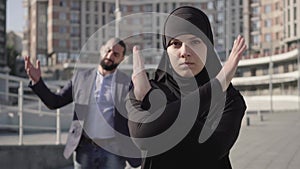 Stressed confident muslim woman turning from man yelling at the background and gesturing no by crossing hands. Portrait