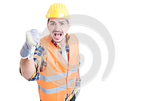 Stressed constructor yelling and standing with fist up