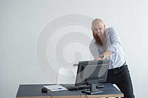 Stressed crazy businessman smashing his computer in office using ax problem concept. The man has problems at work and