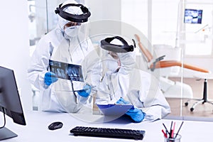 Stressed dentist and nurse examining teeth x-ray