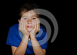 Stressed,depressed,unhappy little boy holding his head over bla