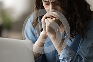 Stressed desperate young woman sitting at laptop with closed eyes