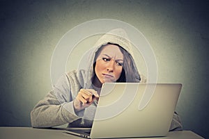 Stressed displeased worried woman sitting in front of laptop computer