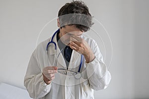 Stressed doctor with hand on his face. Burn out concept for healthcare professions