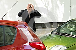 Stressed driver looking at car after traffic collision