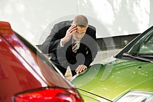 Stressed driver looking at car after traffic collision