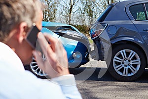 Stressed Driver Sitting At Roadside After Traffic Accident