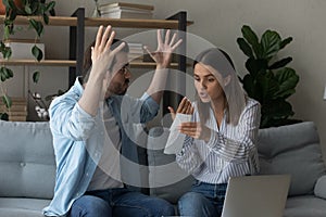 Stressed emotional couple arguing fighting when checking financial papers