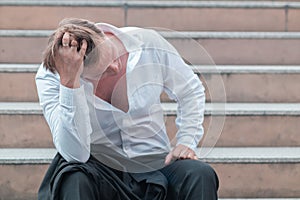 Stressed employee, businessman, wearing a suit, holding his forehead in stress After being fired And failed in business