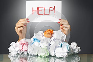 Stressed employee covered with wastepaper at work, asking for help