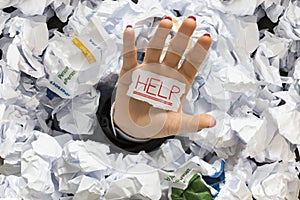 Stressed employee covered with wastepaper at work, asking for help