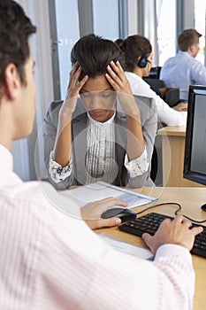 Stressed Employee Working In Busy Office