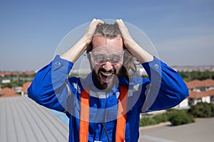 Stressed engineer grab his head suffer from acrophobia while working on the factory rooftop