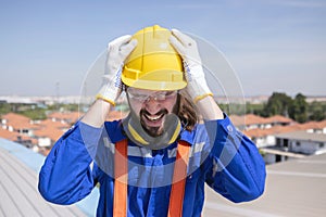 Stressed engineer grab his head suffer from acrophobia while working on the factory rooftop