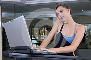 Stressed executive woman in the gym with lap top