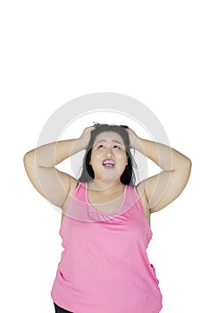 Stressed fat woman scratching her head on studio