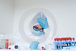 Stressed female doctor sitting tired at his desk. Mid adult female doctor working long hours in protective clothes