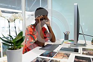 Stressed female graphic designer sitting at desk