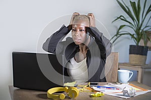 Stressed and frustrated afro American black woman working overwhelmed and upset at office laptop computer desk gesturing sad and d