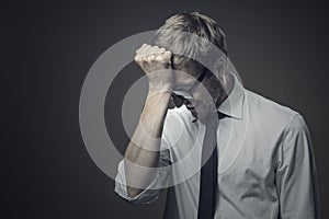 Stressed frustrated businessman making a facepalm gesture