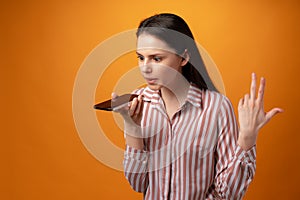 Stressed frustrated young woman holding smartphone, recieved bad news, yellow background
