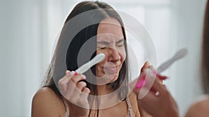 Stressed girl holding pregnancy test mirror place. Woman sad of unplanned baby