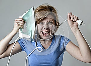Stressed housewife or maid domestic service woman holding upset iron strangling neck with cable photo