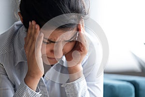 Stressed indian girl touch temples reduces unbearable headache closeup image