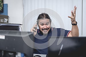 A stressed and irate man arguing over the phone with someone. Furious with an absent or underperforming staff member. Office