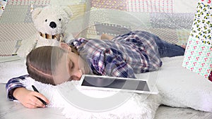 Stressed kid sleeping while studying on tablet, child asleep writing homework, children education