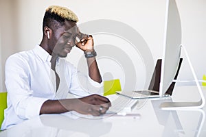 Stressed Male Businessman with head ache sitting with head in Hand At Desk In Office