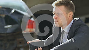 Stressed male taking pill feeling nervous after auto accident, talking on phone